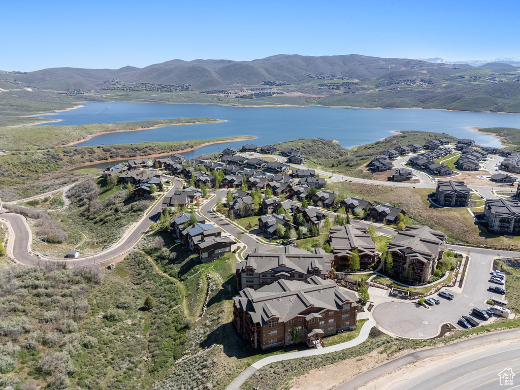 Aerial view of property's location with a water and mountain view and nearby suburban area