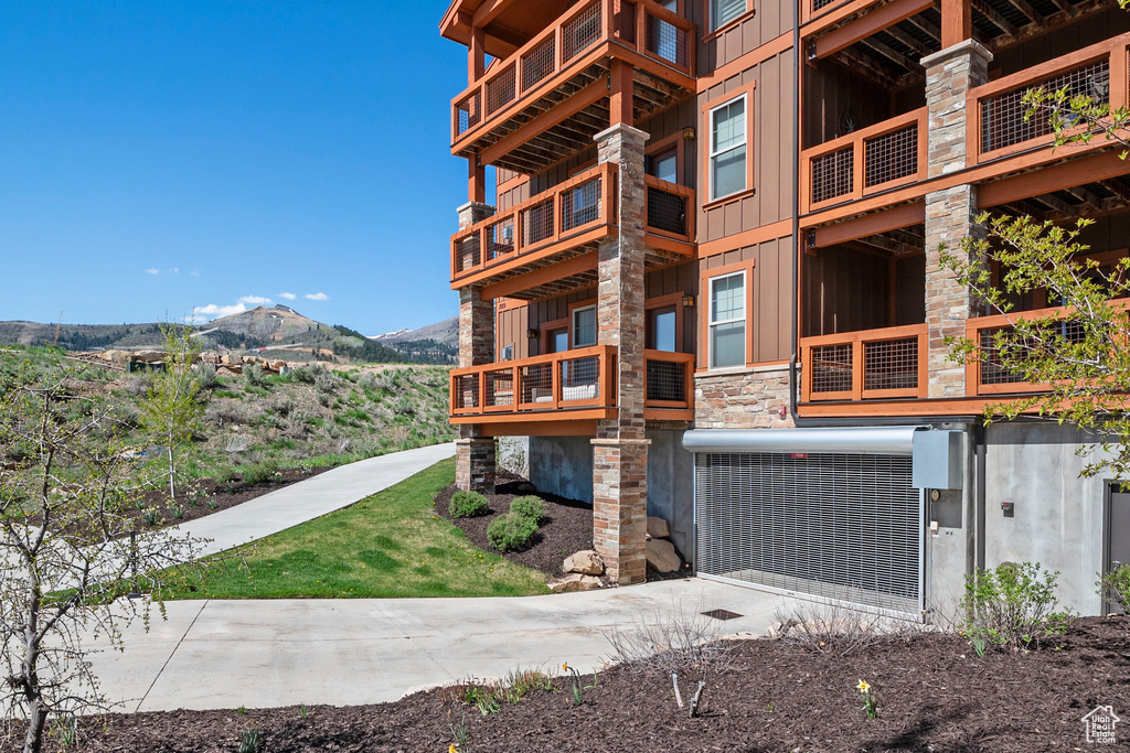 View of building exterior featuring a mountain view and concrete driveway