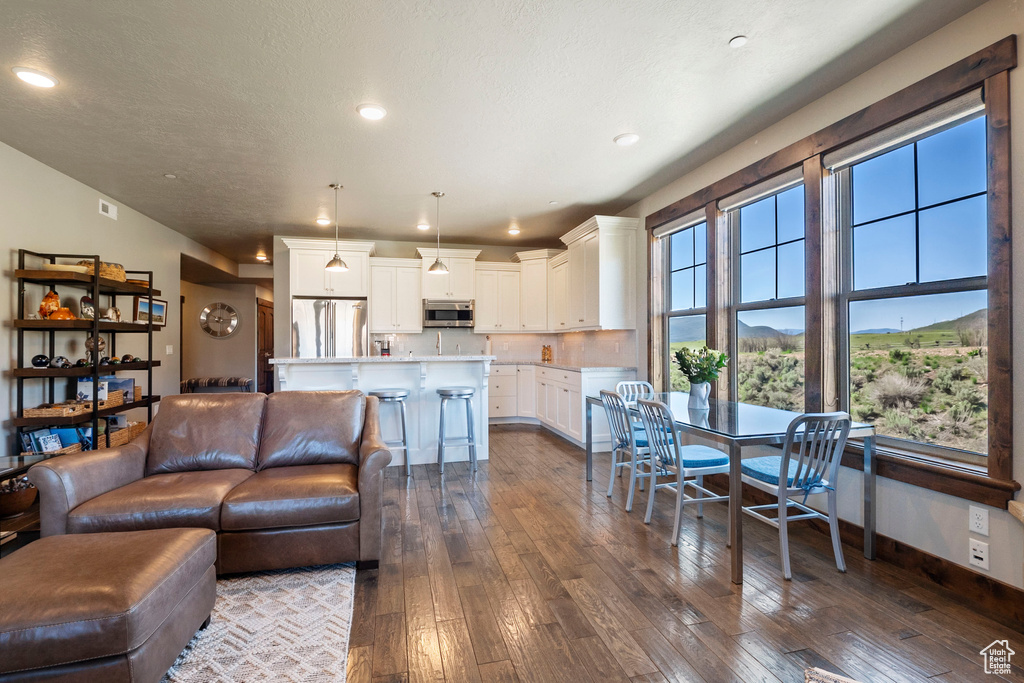 Living area featuring dark wood-type flooring, recessed lighting, and baseboards