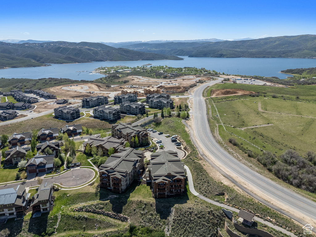 Aerial view of property and surrounding area with a water and mountain view