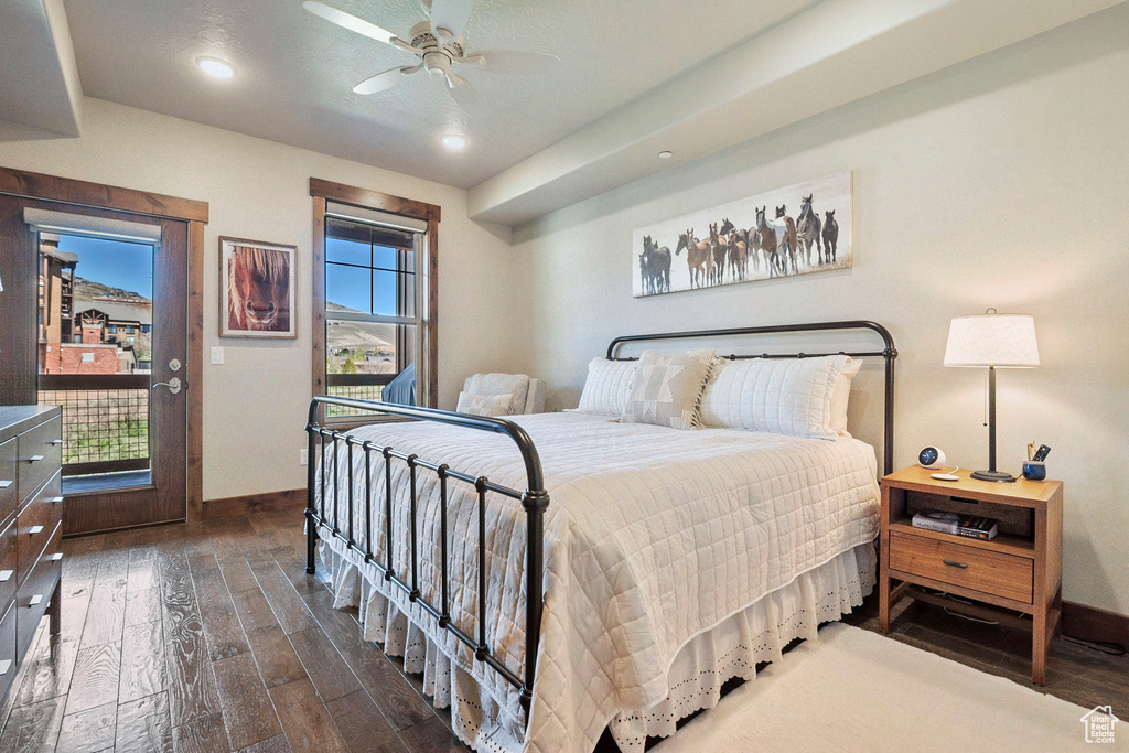 Bedroom featuring dark wood-type flooring, baseboards, ceiling fan, and access to exterior