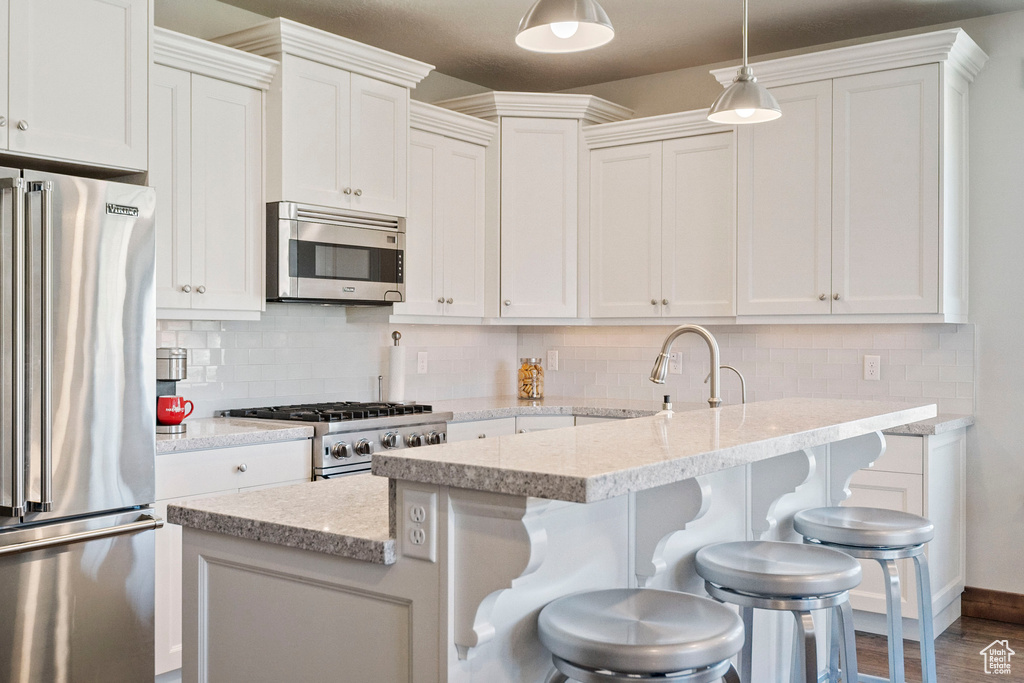 Kitchen featuring appliances with stainless steel finishes, a sink, and white cabinets