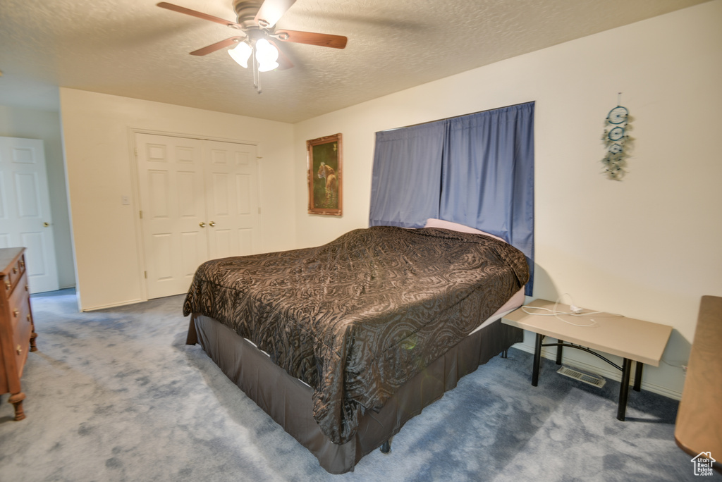 Bedroom featuring carpet, a textured ceiling, baseboards, and a ceiling fan