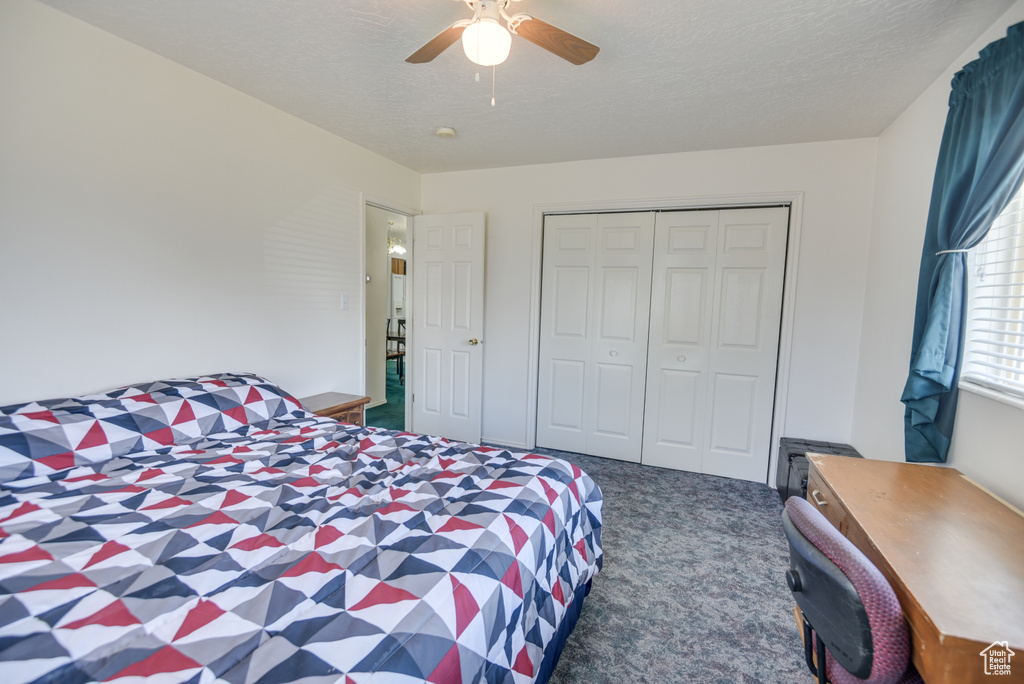 Bedroom featuring carpet, ceiling fan, a closet, and a textured ceiling