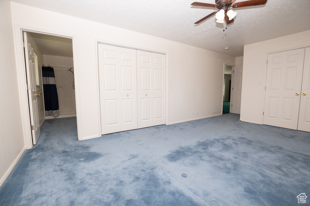 Unfurnished bedroom featuring carpet, a textured ceiling, and a ceiling fan