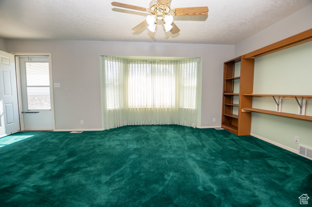 Spare room with carpet, a textured ceiling, and ceiling fan