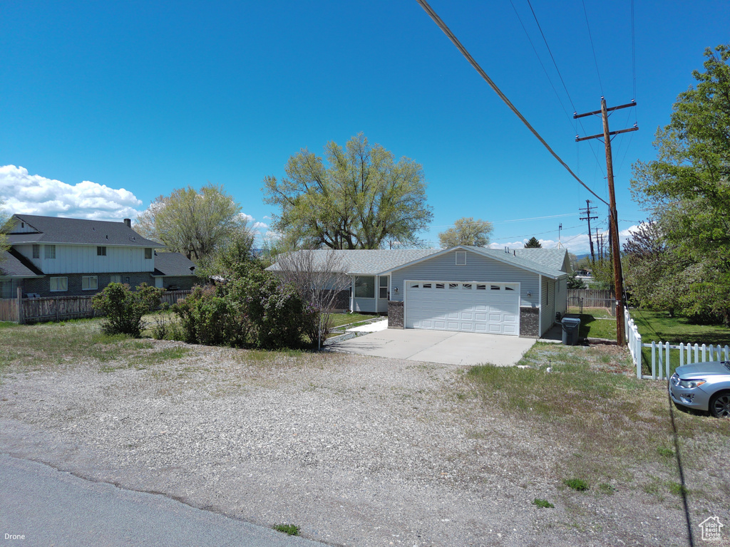View of front of home with an attached garage, fence, and driveway