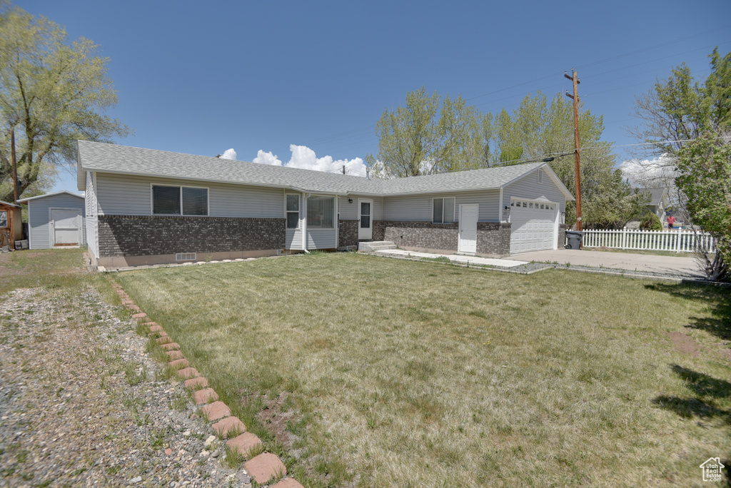 Single story home featuring an attached garage, brick siding, and driveway