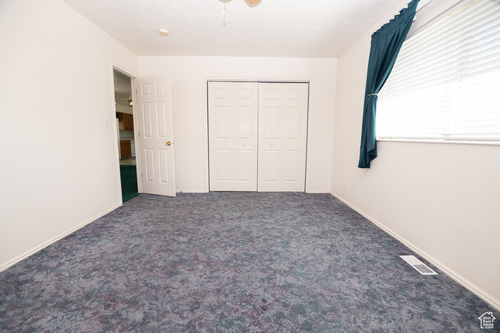 Unfurnished bedroom featuring carpet, a closet, and ceiling fan