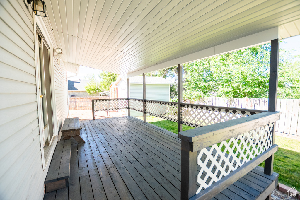 Wooden terrace with a fenced backyard and an outdoor structure