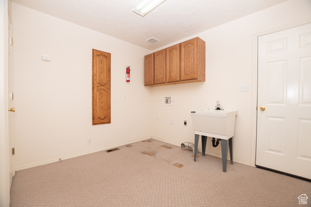 Laundry room with hookup for a washing machine, light colored carpet, cabinet space, and hookup for an electric dryer