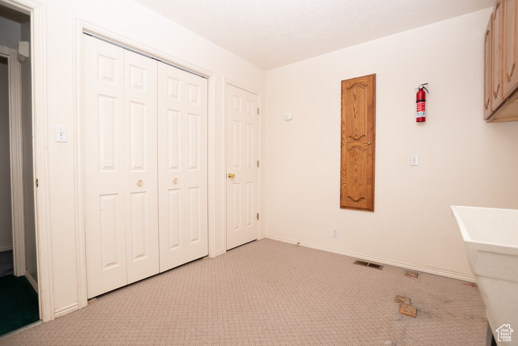 Unfurnished bedroom featuring light carpet and a closet