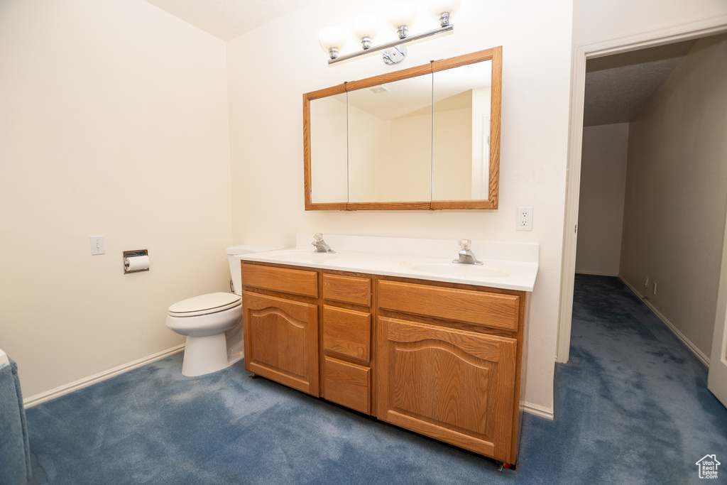 Full bath featuring double vanity and toilet