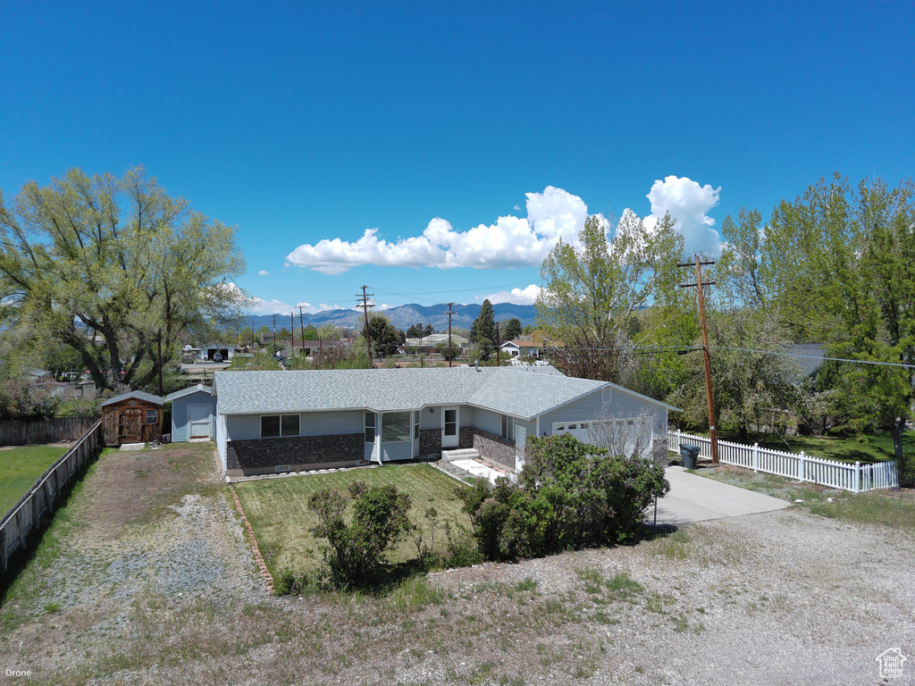 View of front of home with concrete driveway, a mountain view, roof with shingles, and an attached garage