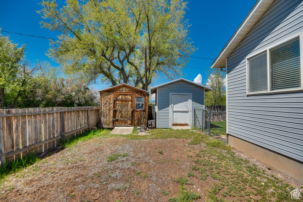 Fenced backyard with a shed and an outdoor structure
