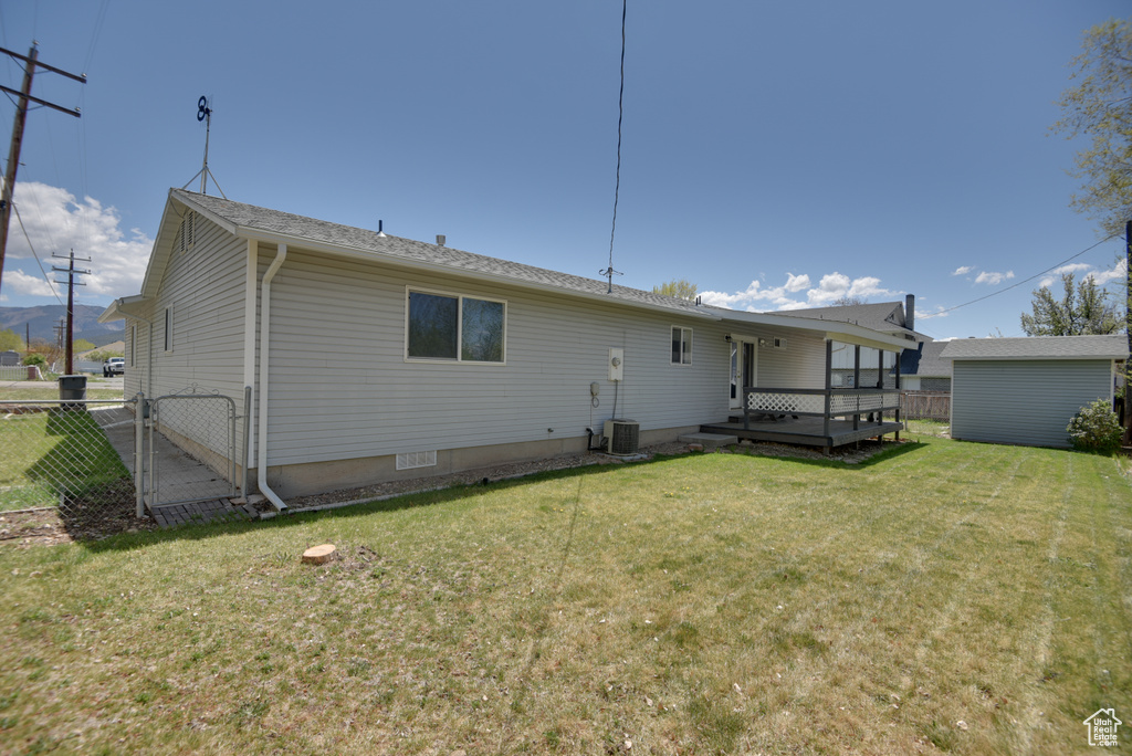 Back of house featuring a wooden deck and a gate