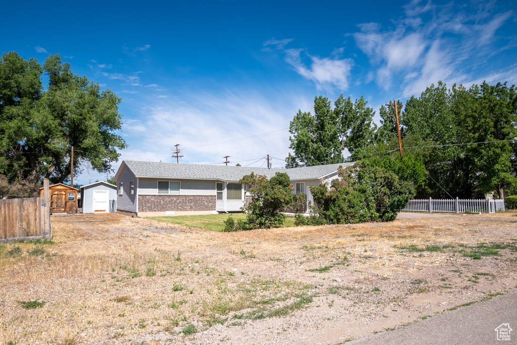 View of front of home with a shed