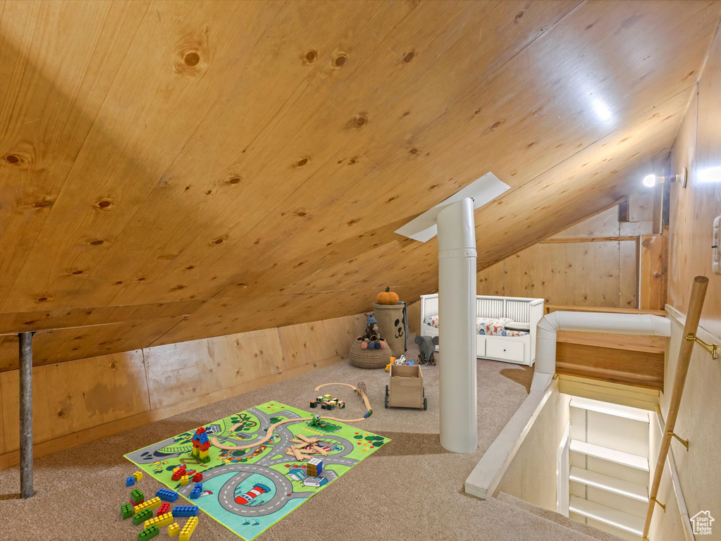 Playroom with lofted ceiling, carpet flooring, wooden walls, and wood ceiling