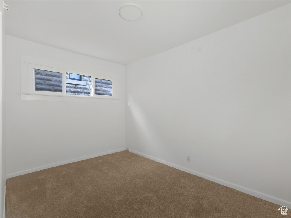 Carpeted spare room with baseboards
