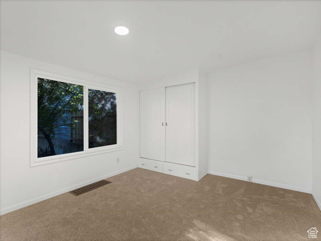 Carpeted empty room with baseboards
