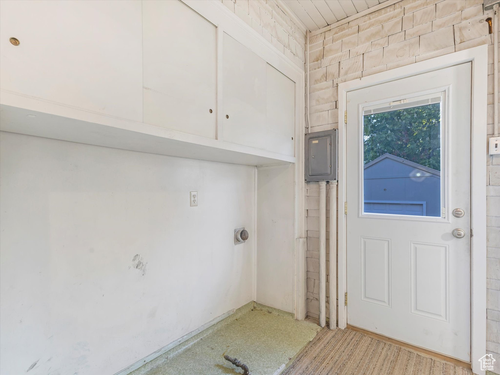 Laundry area featuring electric panel and carpet flooring