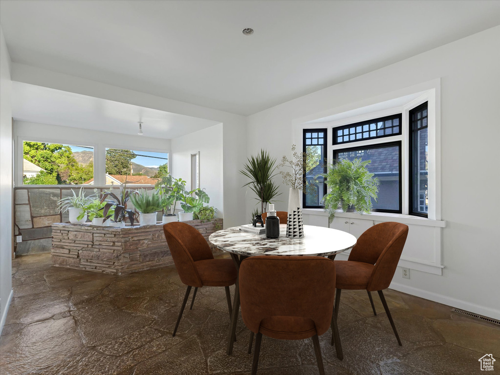Dining room with stone tile flooring and plenty of natural light