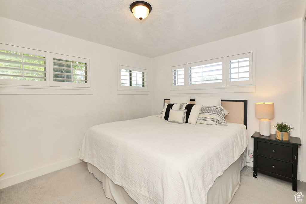 Bedroom with light colored carpet and baseboards