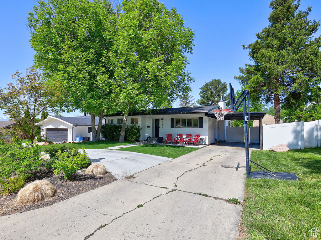 Ranch-style home with concrete driveway, an attached garage, and an attached carport