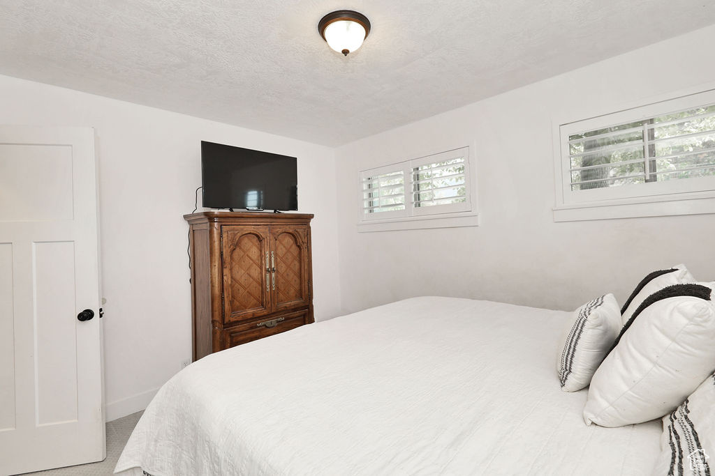 Carpeted bedroom with a textured ceiling and baseboards