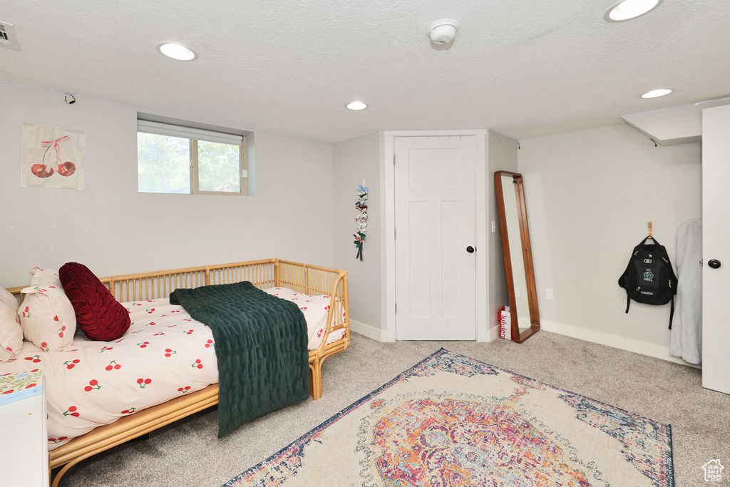 Carpeted bedroom featuring recessed lighting, baseboards, and a textured ceiling