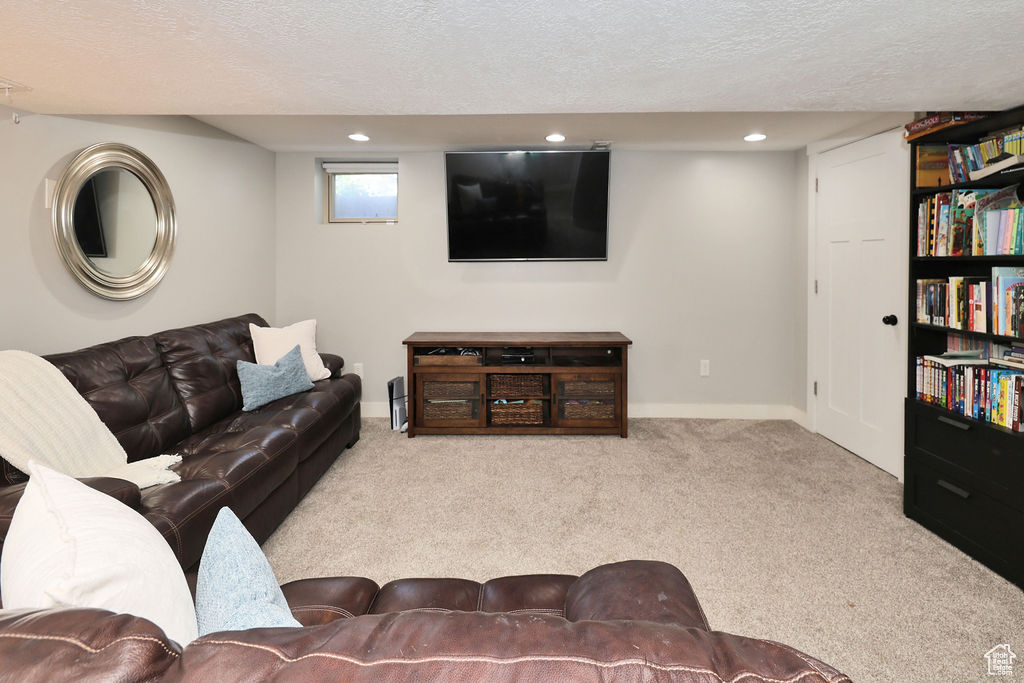 Living area featuring a textured ceiling, carpet floors, recessed lighting, and baseboards