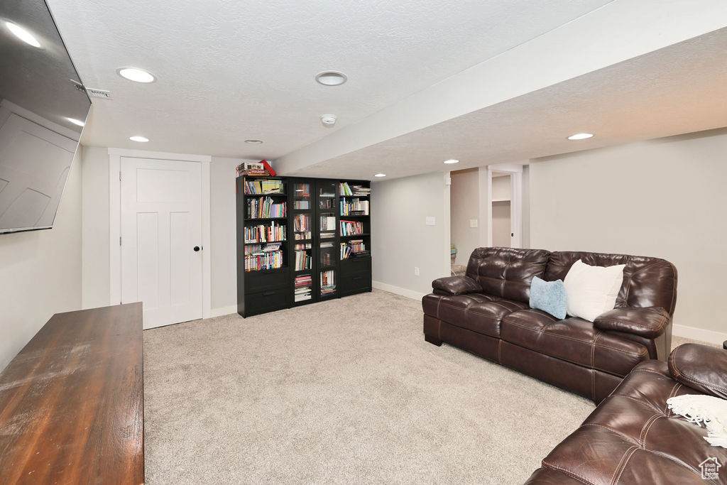 Carpeted living area with recessed lighting and baseboards