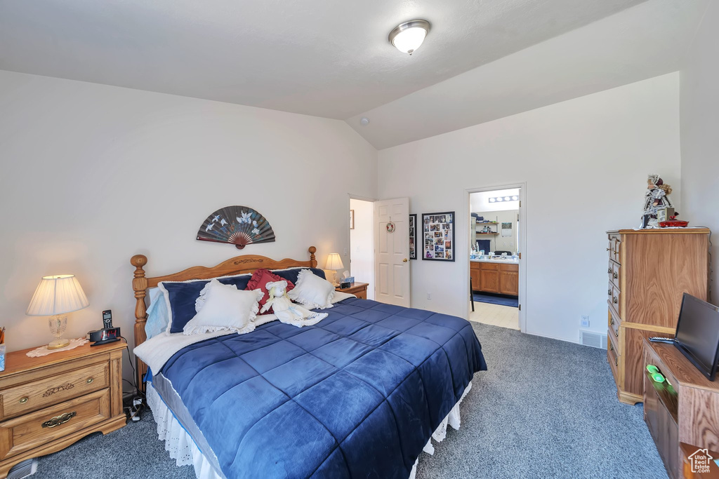 Carpeted bedroom with lofted ceiling and ensuite bathroom
