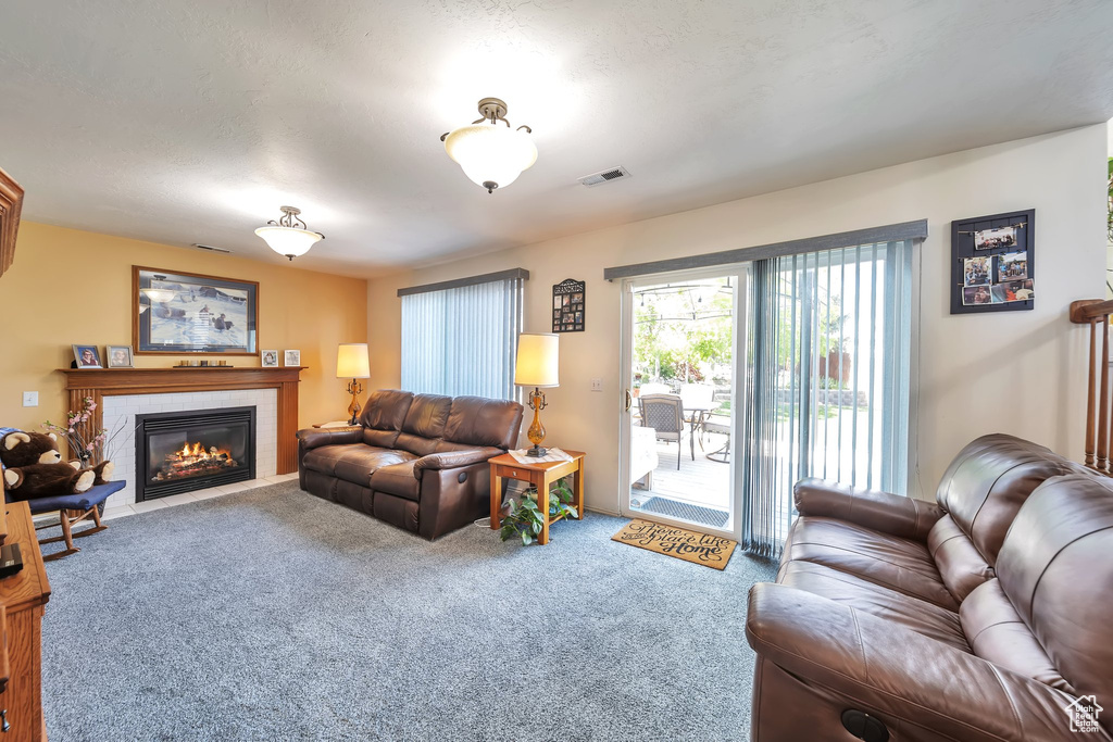 Carpeted living room featuring a tile fireplace