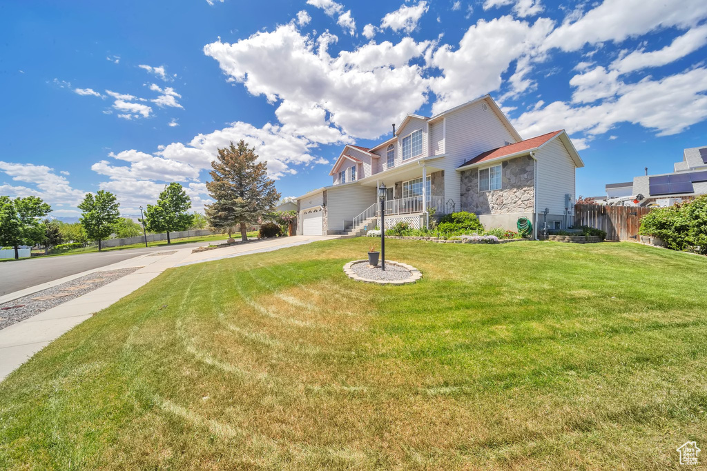 View of front of home featuring stone siding, concrete driveway, and a garage