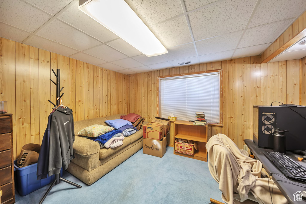 Carpeted bedroom with a paneled ceiling and wooden walls
