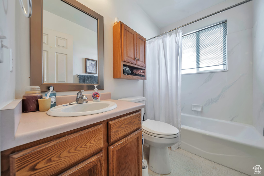 Bathroom with toilet, vanity, and shower / bath combination with curtain