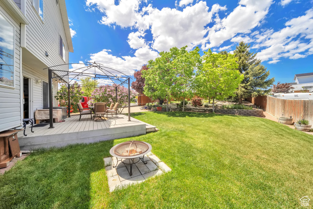 View of yard with a fire pit, a gazebo, and a deck