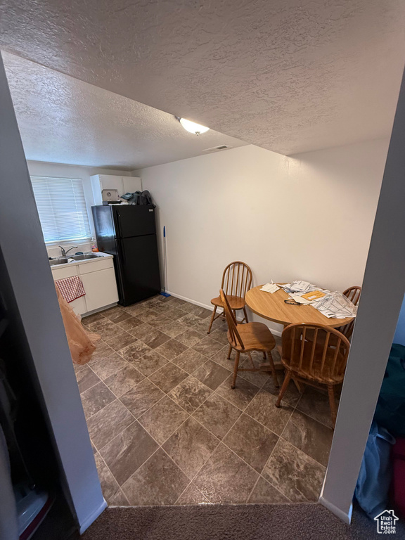 Dining space featuring a textured ceiling and baseboards