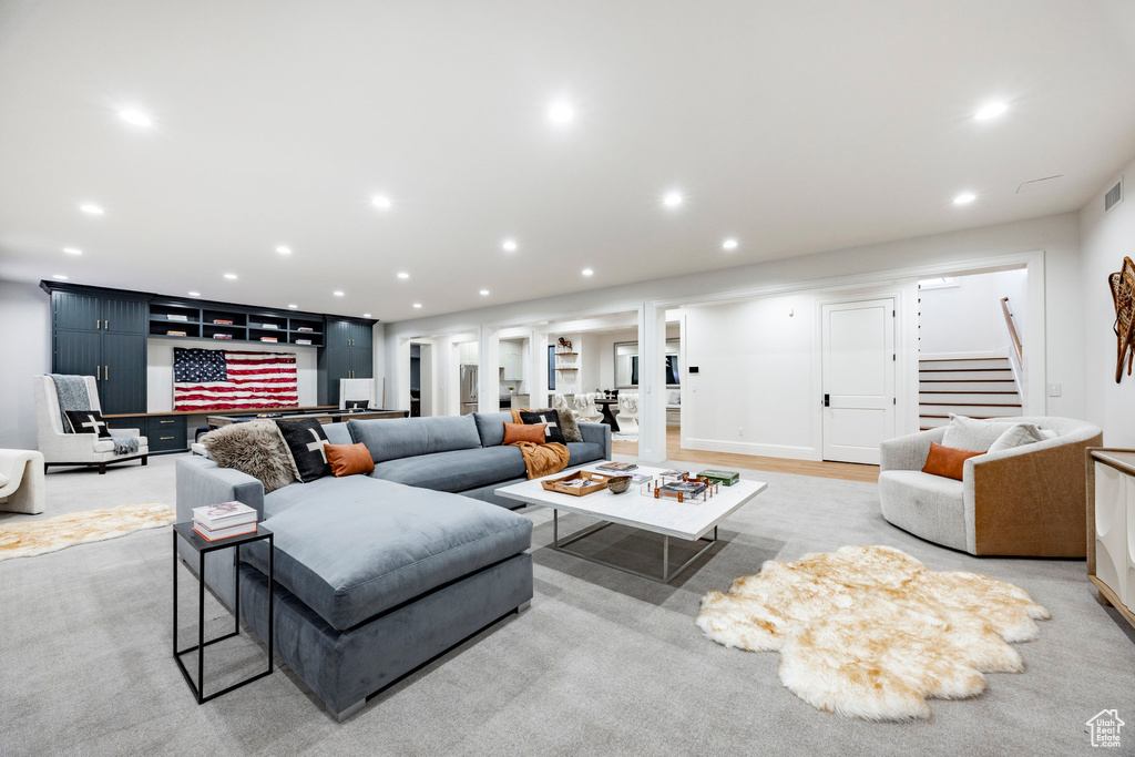 Living room with stairs, recessed lighting, bar area, and ornate columns