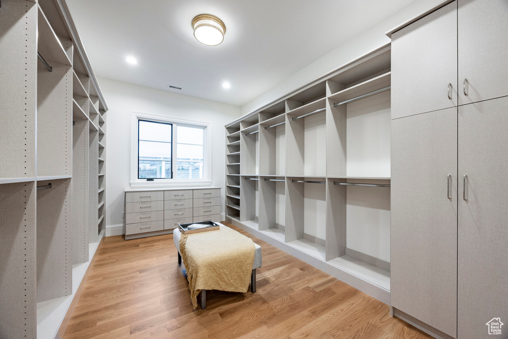 Walk in closet with light wood-type flooring