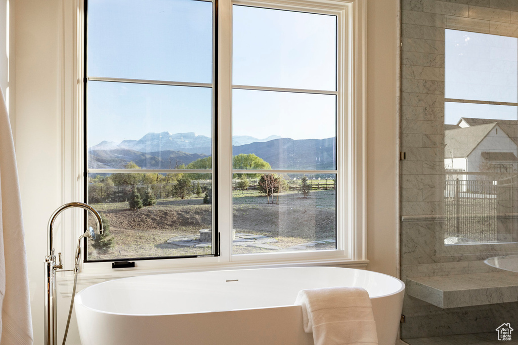 Full bath featuring a mountain view, a freestanding tub, and a tile shower