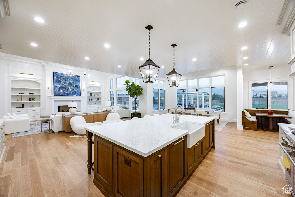 Kitchen featuring a sink, a chandelier, light wood-style flooring, open floor plan, and recessed lighting