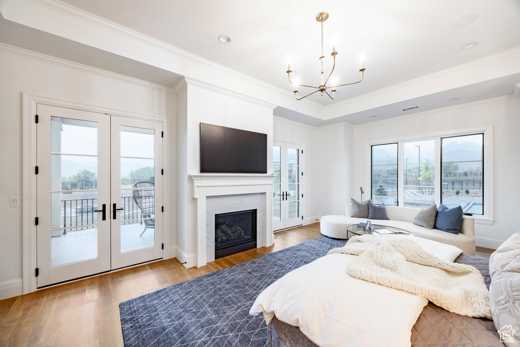 Bedroom with a chandelier, access to outside, french doors, light wood-style floors, and crown molding