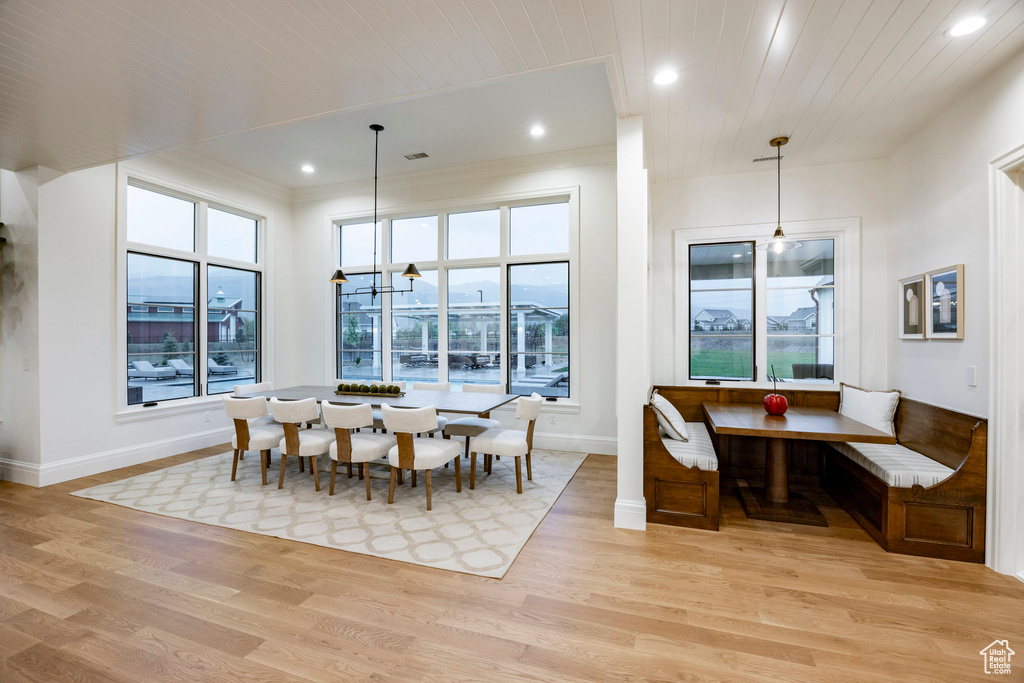 Dining area with baseboards, healthy amount of natural light, breakfast area, light wood finished floors, and recessed lighting