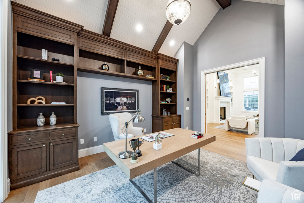 Office space featuring a fireplace, light wood-type flooring, baseboards, and wooden ceiling