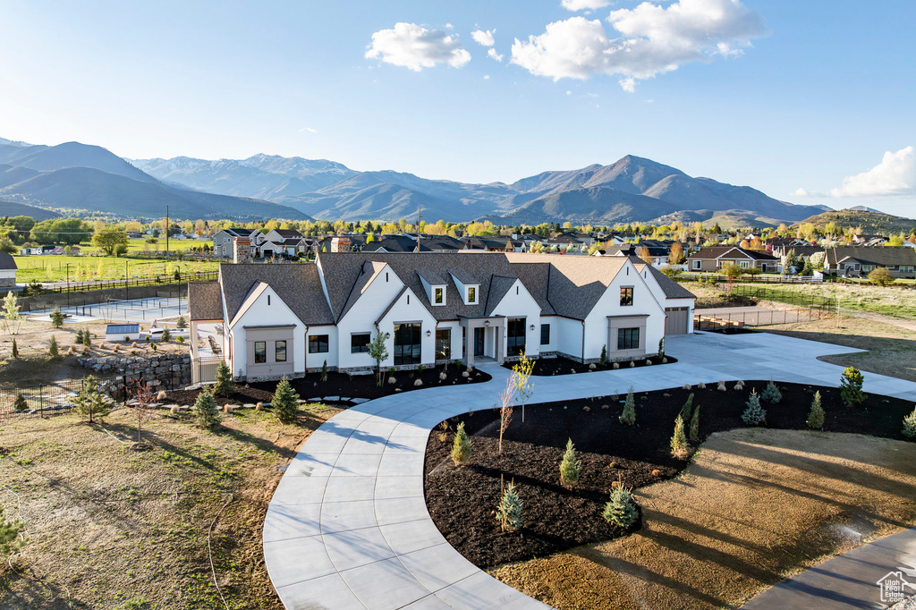 View of front of house with a residential view, a mountain view, and fence