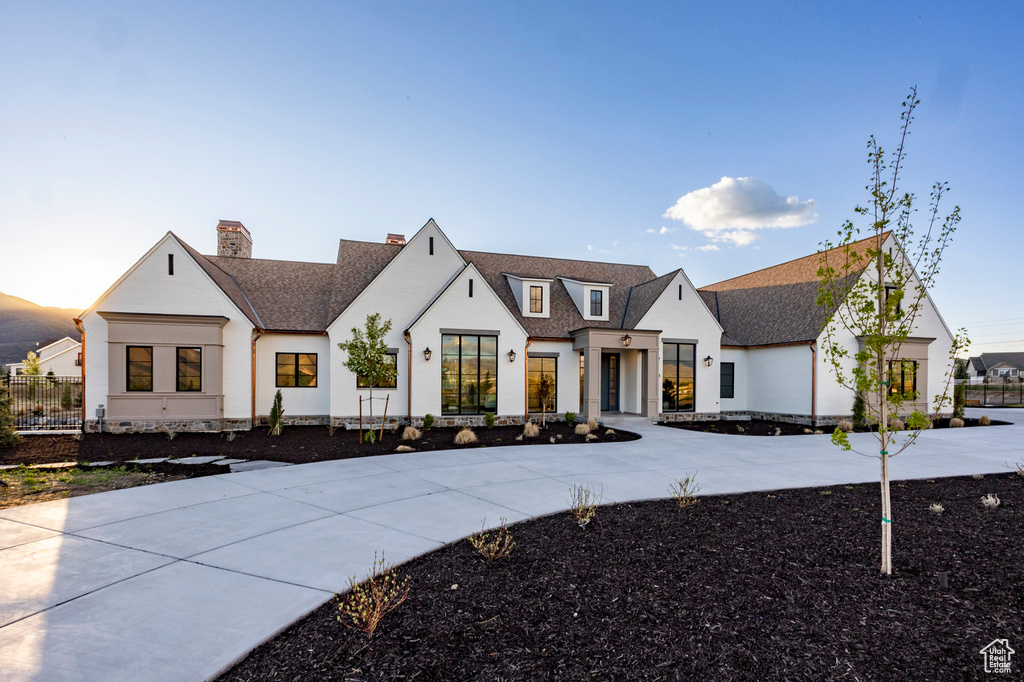 Modern inspired farmhouse with a shingled roof and a chimney