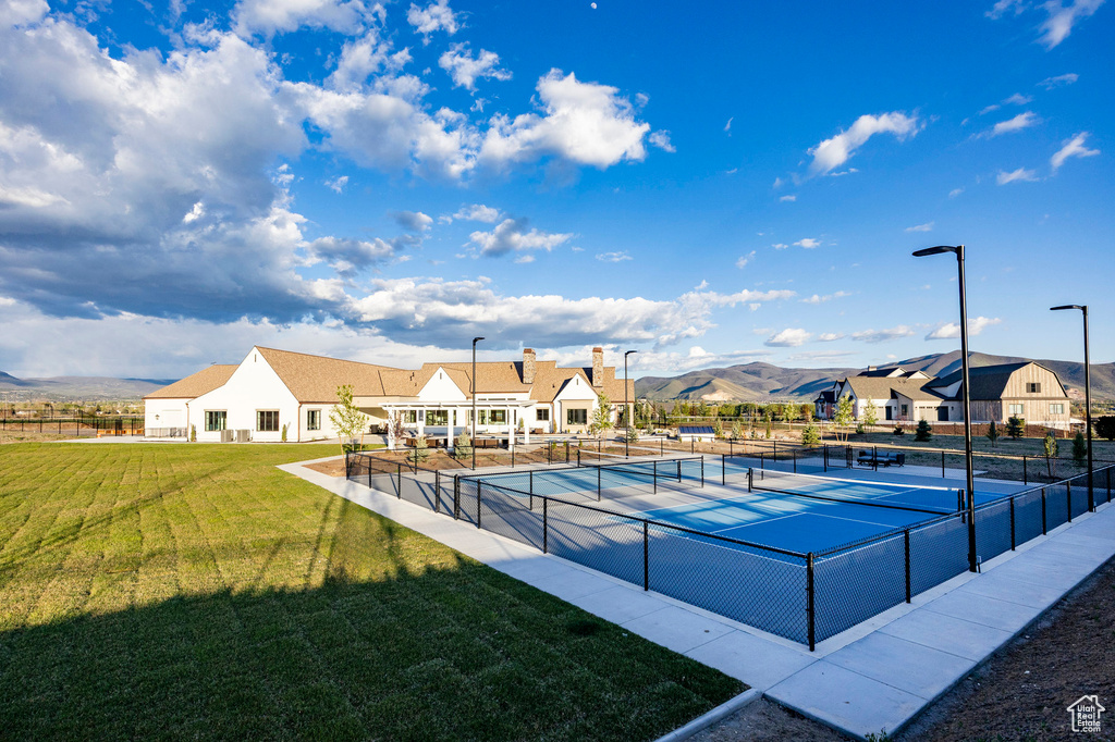 View of swimming pool with a tennis court and a mountain view