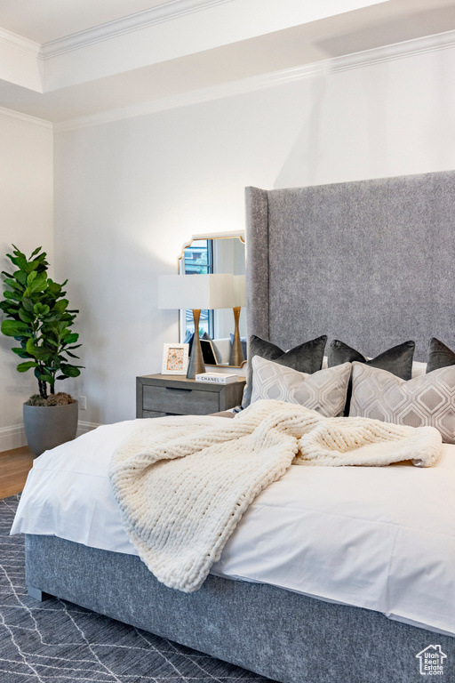 Bedroom with crown molding, wood finished floors, and baseboards